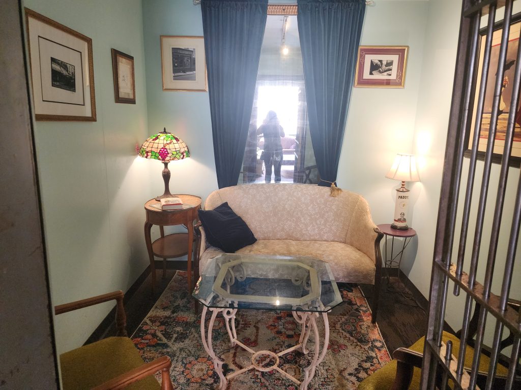 Small sitting area with a sofa, glass coffee table, and table lamps.