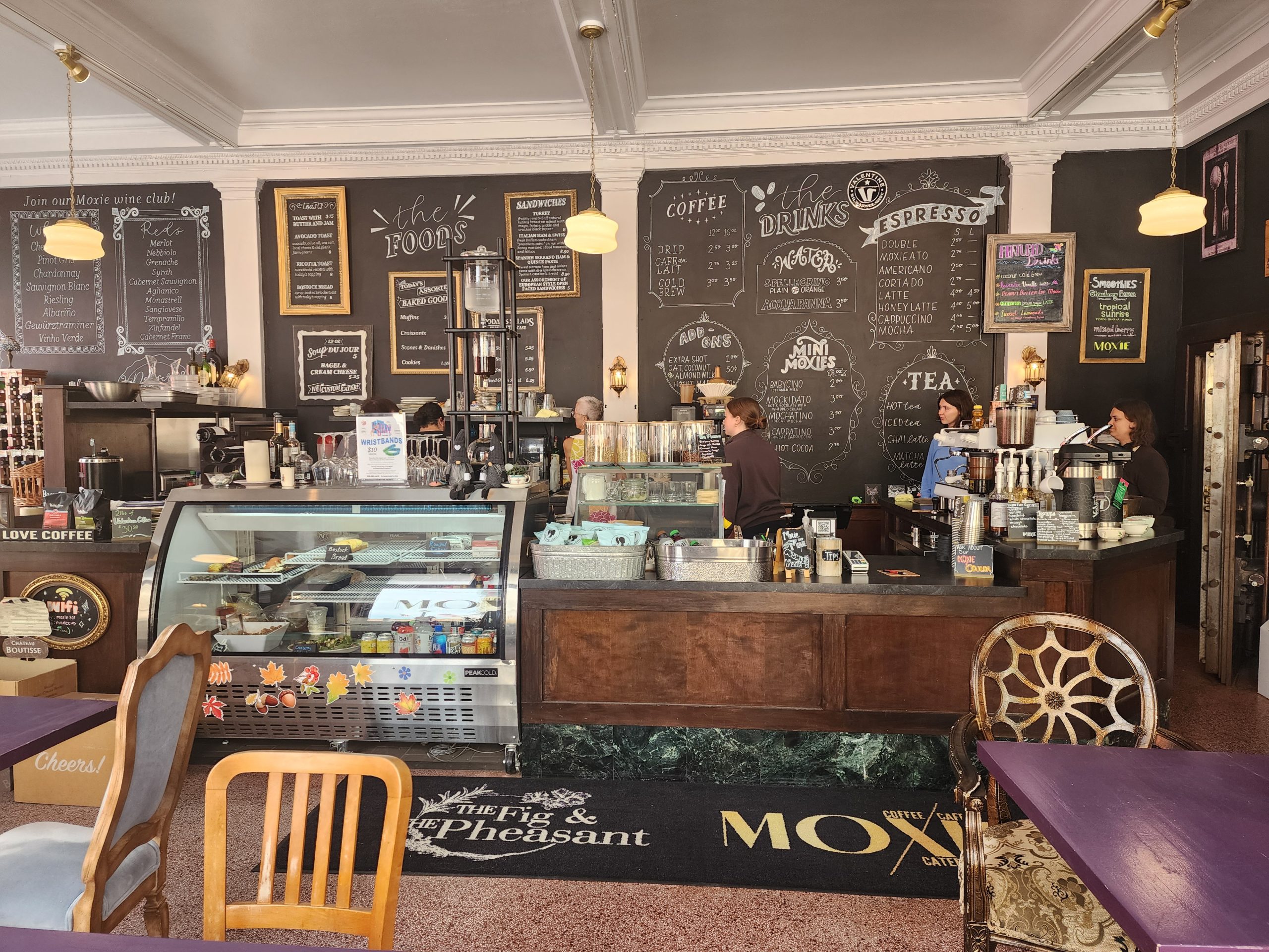 Cafe interior with coffee counter, menu boards, and seating.