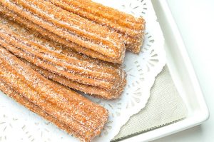 Churros on a plate with a decorative napkin