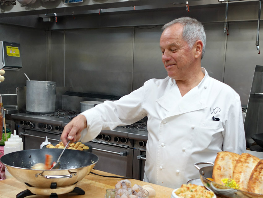 Chef in a white jacket cooking in a commercial kitchen.