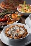 A close-up of various Mediterranean dishes including pasta, grilled vegetables, and a fresh salad.