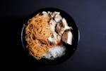A close-up view of a bowl filled with noodles, rice, and chicken, perfect for a healthy meal.