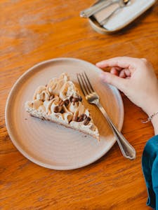 A delectable slice of coffee cream cake elegantly presented on a wooden table, perfect for a cozy café setting.