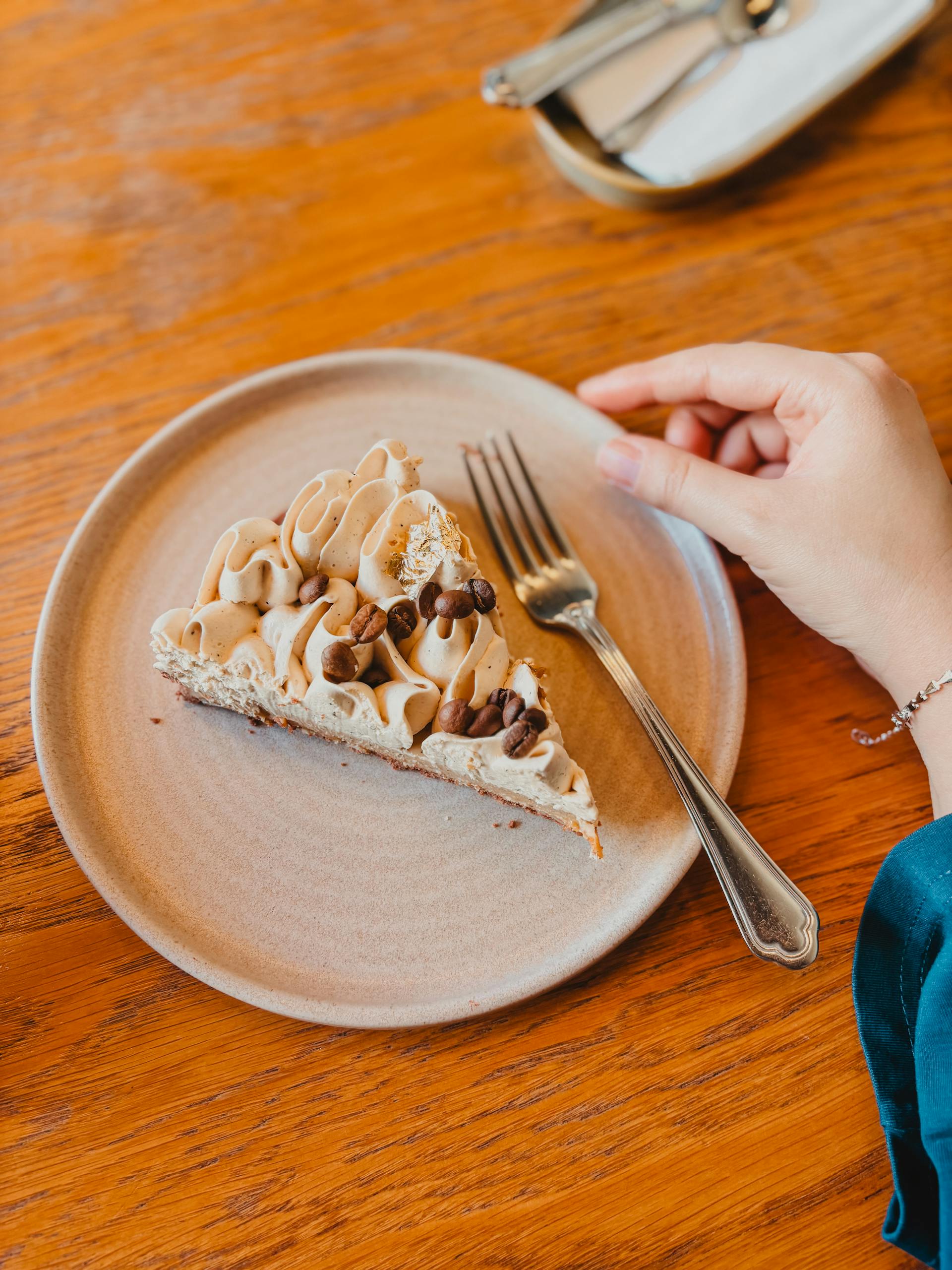 A delectable slice of coffee cream cake elegantly presented on a wooden table, perfect for a cozy café setting.