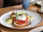 A delicious brunch dish featuring smoked salmon, poached eggs, and hollandaise sauce on toast.