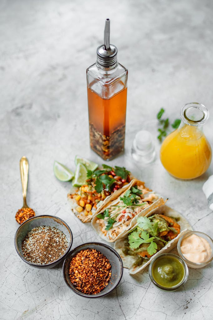 A delicious spread of Mexican tacos with sauces and vibrant spices, perfect for food enthusiasts.