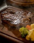 A deliciously grilled steak served with fresh steamed broccoli and cauliflower.