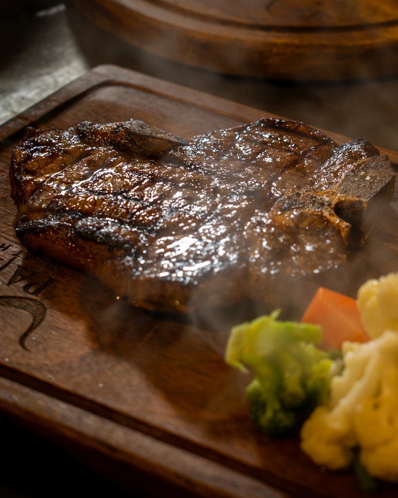 A deliciously grilled steak served with fresh steamed broccoli and cauliflower.