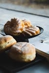 A selection of German donuts and pastries on a rustic table setting in soft daylight.