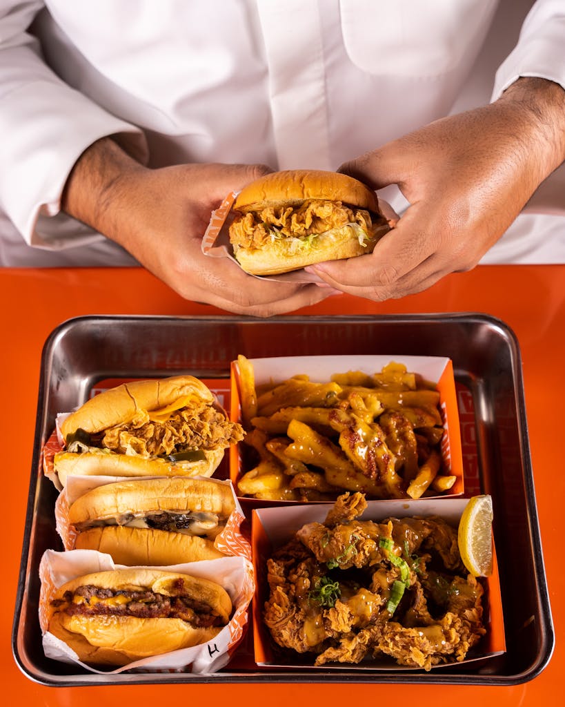 A tempting flat lay of fried food including burgers, fries, and chicken.