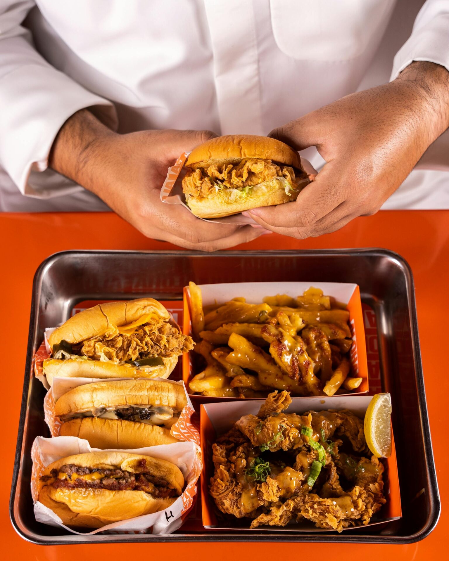A tempting flat lay of fried food including burgers, fries, and chicken.