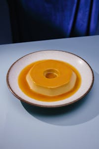 A tempting plate of Brazilian Quindim dessert served under bright lighting.