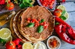 A top-down view of delicious homemade Turkish lahmacun garnished with fresh basil and vibrant ingredients.