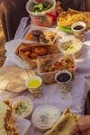 A vibrant spread of Middle Eastern dishes including falafel, salads, and dips in an outdoor setting.