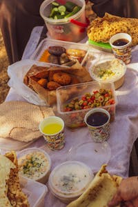 A vibrant spread of Middle Eastern dishes including falafel, salads, and dips in an outdoor setting.