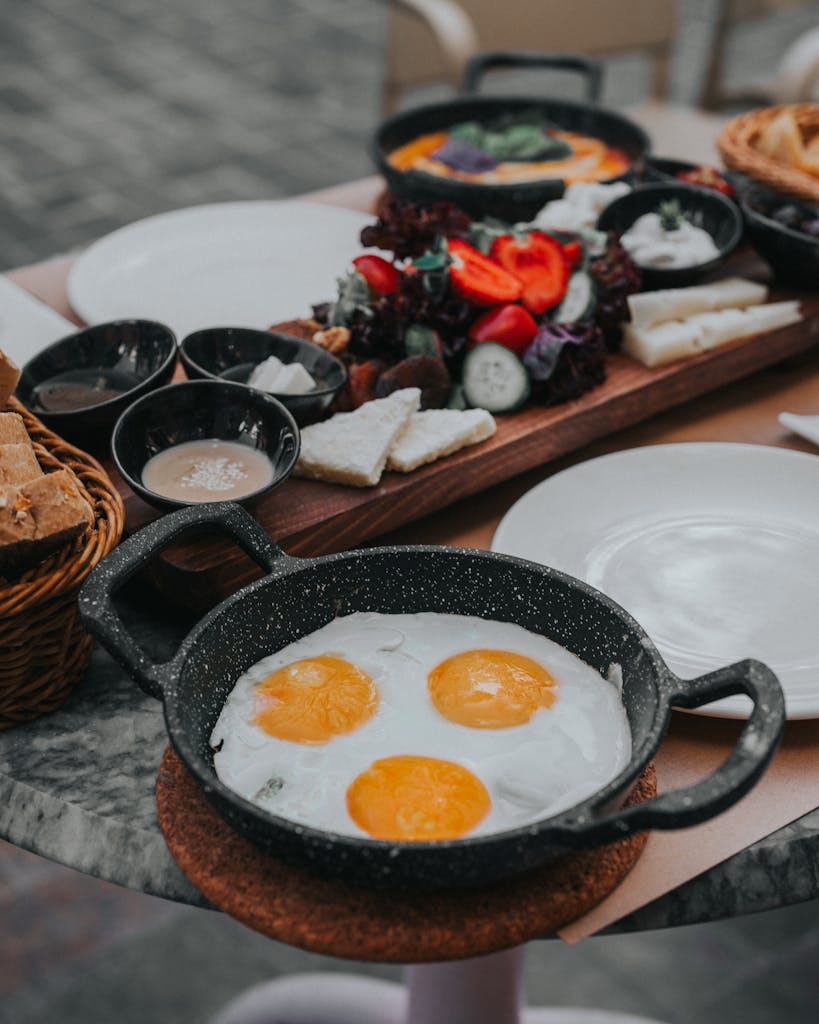 A vibrant Turkish breakfast with fried eggs, fresh vegetables, and more in Antalya.