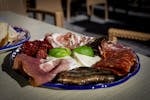 An appetizing Italian antipasto platter featuring cured meats, cheese, and roasted vegetables.
