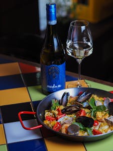 Appetizing seafood paella paired with wine, perfect for a delicious meal setting.