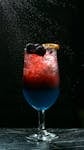 Artistic shot of a vibrant berry and citrus cocktail with dark background.