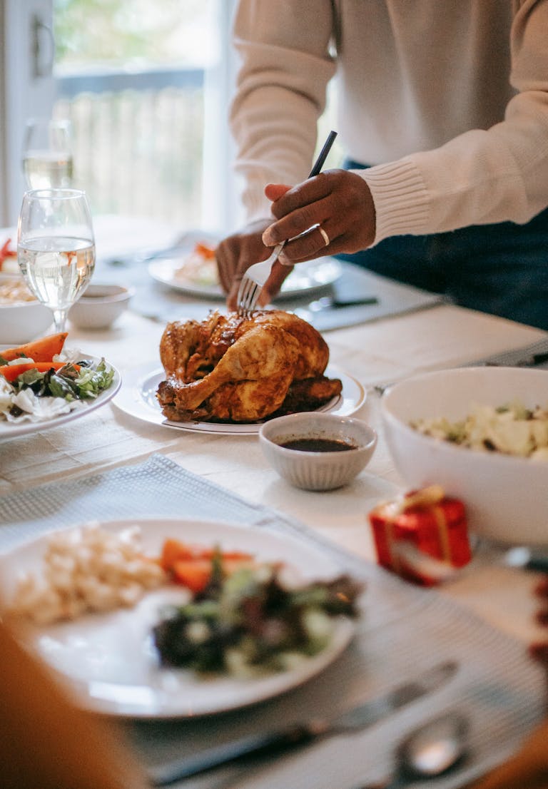 Celebratory meal with roast chicken, salads, and sides set on an elegant dining table.