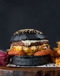 Close-up of a gourmet burger with a black bun and fries. Perfect for food photography.