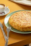 Close-up of a homemade Spanish omelette with coffee, perfect for breakfast.
