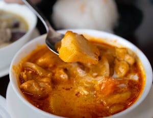 Close-up of a vibrant curry dish with fresh ingredients in a Tokyo restaurant setting.