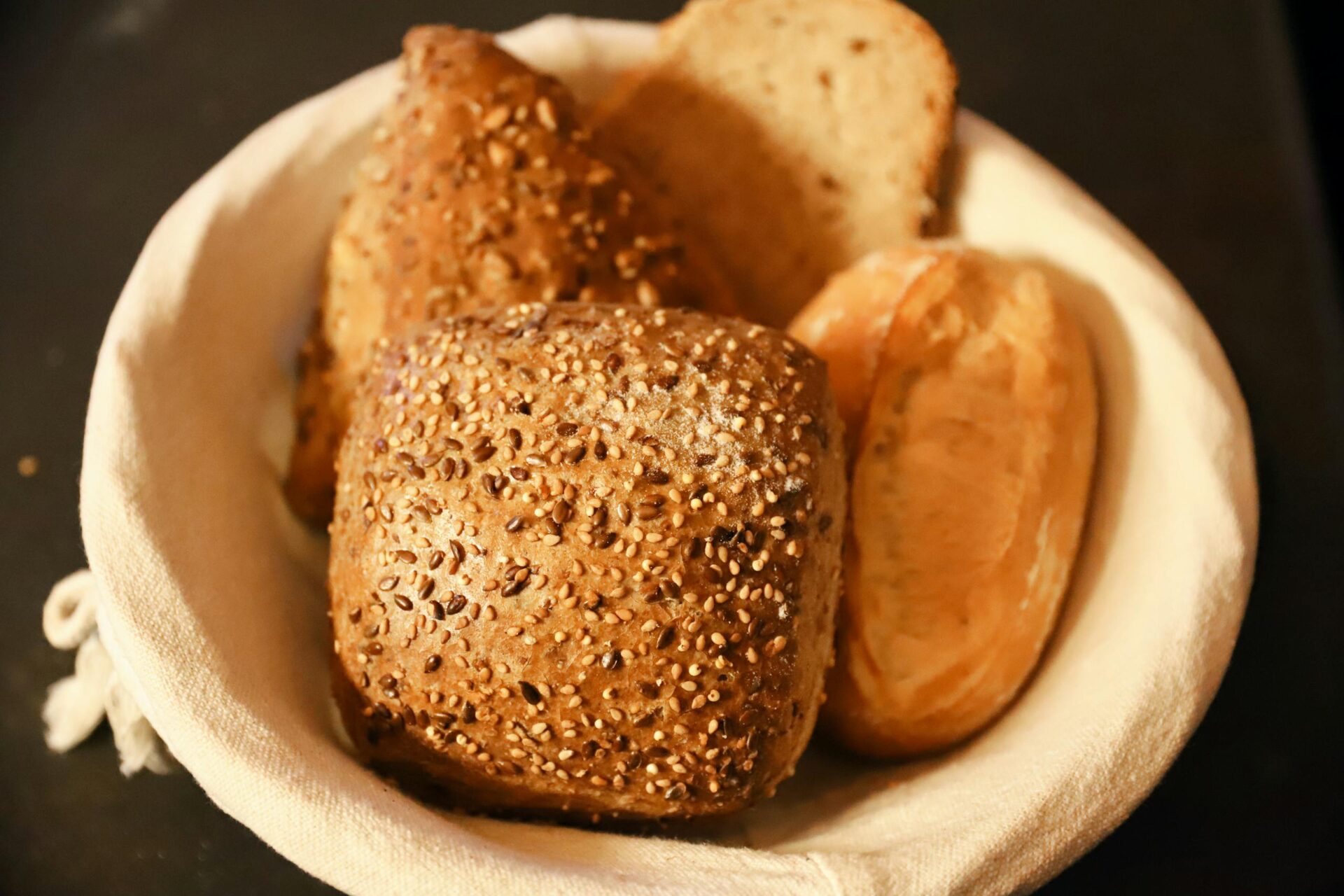 Close-up of assorted freshly baked bread rolls in a basket, perfect for breakfast or brunch.