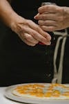 Close-up of chef seasoning a gourmet egg dish with pepper, showcasing culinary expertise.