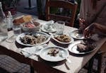 Cozy outdoor dining with a variety of Greek dishes shared among friends on a summer day.