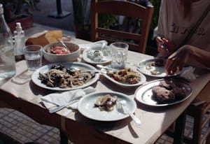 Cozy outdoor dining with a variety of Greek dishes shared among friends on a summer day.