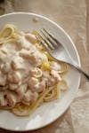 Delicious creamy shrimp pasta with a rich sauce served on a white plate, perfect for gourmet dining.