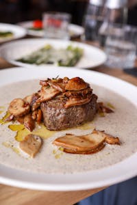 Delicious fillet steak served with wild mushrooms and creamy sauce on a plate in a restaurant.