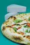 Delicious gourmet pizza topped with fresh ingredients, featuring blocks of cheese in the background.