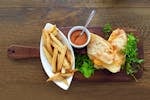 Delicious grilled cheese sandwich with crispy fries and a side of dipping sauce on a wooden table.
