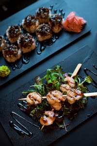 Delicious grilled shrimp skewers served with mixed greens and balsamic glaze, perfect for a gourmet dining experience.