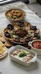 Delicious Mediterranean feast with a variety of dips and roasted vegetables.