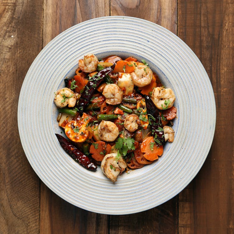 Delicious shrimp and vegetable dish served on a white plate, perfect for a gourmet meal.