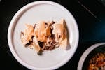 Elegant gourmet dish features crispy wonton chips and savory beef on a ceramic plate.