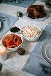 From above of appetizing pasta salad near sliced tomatoes and turkey on table during New Year holiday