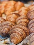 Golden croissants displayed at a bakery in Berlin, Germany, showcasing European pastry art.