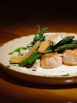 Gourmet dish featuring asparagus, baby corn, and creamy cheese on a ceramic plate.