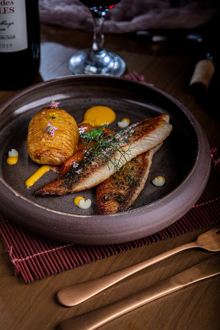 Gourmet fish and potato dish elegantly presented in São Paulo restaurant.