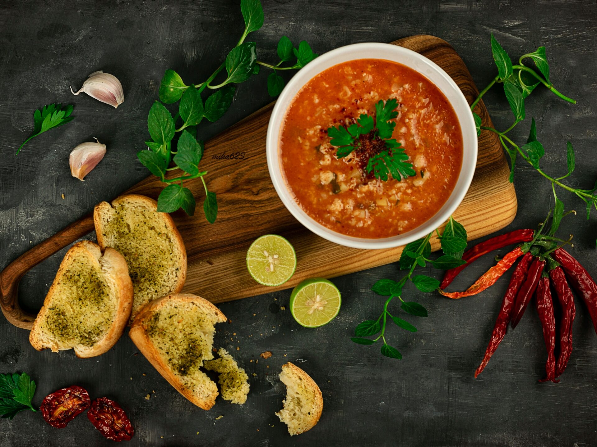 Tomato soup with crisp herb bread and a parsley garnish