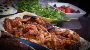Grilled chicken wings served with herb salad and flatbread.