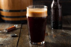 Glass of dark root beer with a foamy head