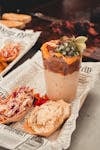 Savor a gourmet barbecue dish with sides, beautifully styled on newspaper in Lisboa, Portugal.
