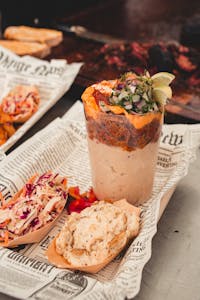 Savor a gourmet barbecue dish with sides, beautifully styled on newspaper in Lisboa, Portugal.
