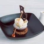 Stylish presentation of gourmet dessert with chocolate garnish and caramel accent.