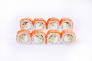 Sushi rolls with salmon, cucumber, and avocado on a white background.